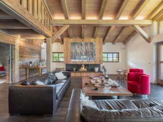 This stunning living room showcases rustic elegance with its exposed wooden beams and cozy fireplace.