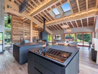 Experience luxury living in this stunning property featuring a modern kitchen with sleek black countertops and a built-in cooktop.