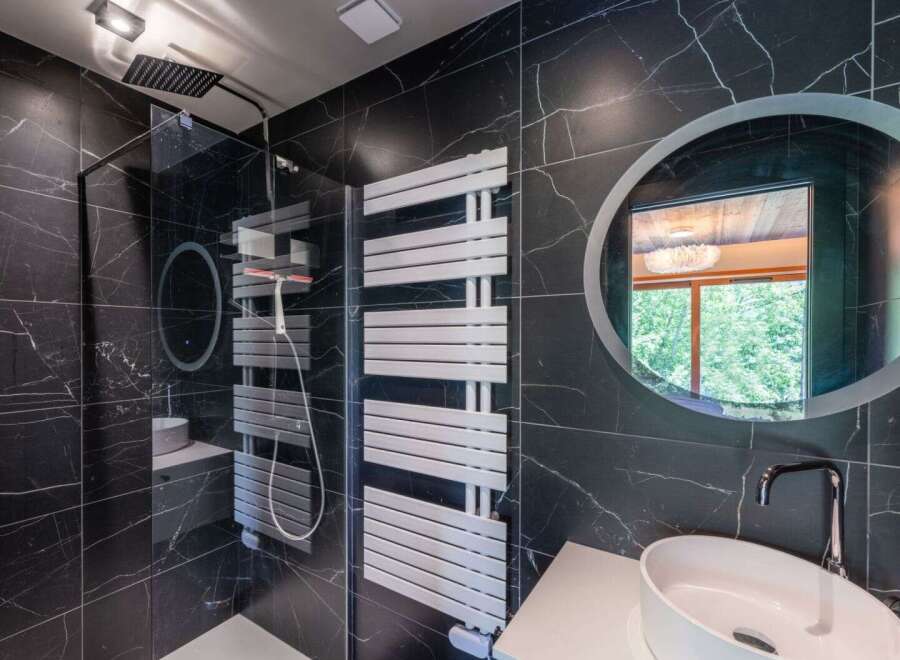 This luxurious bathroom boasts a sleek, modern design with striking black marble walls.