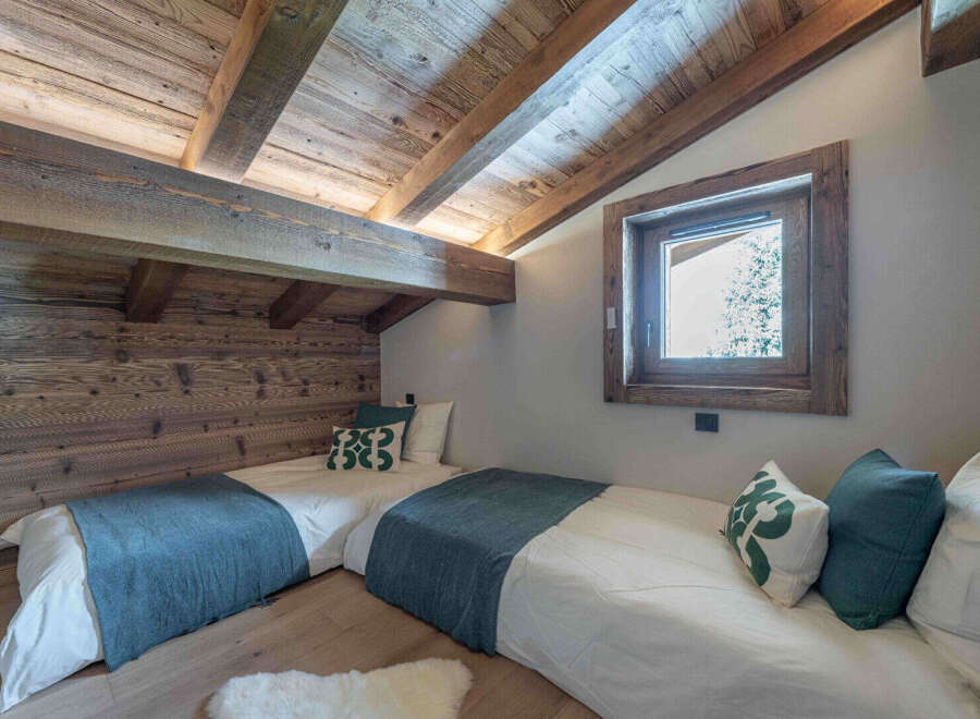 This cozy bedroom features a rustic wooden ceiling and walls, creating a warm and inviting atmosphere.