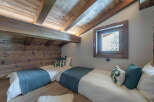 This cozy bedroom features a rustic wooden ceiling and walls, creating a warm and inviting atmosphere.