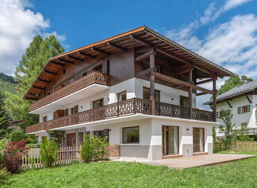 This stunning chalet-style home boasts a beautiful wooden exterior and spacious balconies, perfect for enjoying the mountain views.
