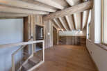 Experience rustic charm in this beautifully appointed attic room, featuring exposed wooden beams and natural wood paneling throughout.