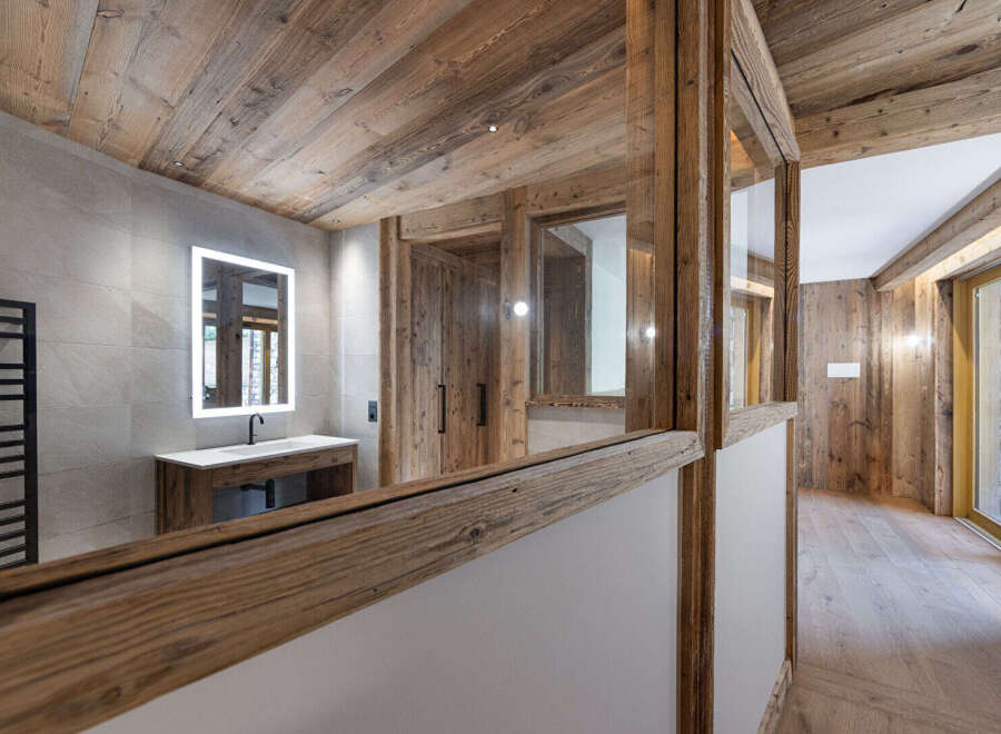 Experience rustic luxury in this stunning bathroom featuring natural wood accents and modern amenities.