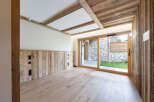 Experience rustic charm in this beautifully appointed room featuring natural wood paneling on the walls and ceiling, complemented by exposed wooden beams.