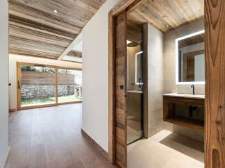 Experience modern alpine living with this stunning property featuring a luxurious bathroom with a sleek vanity and illuminated mirror.