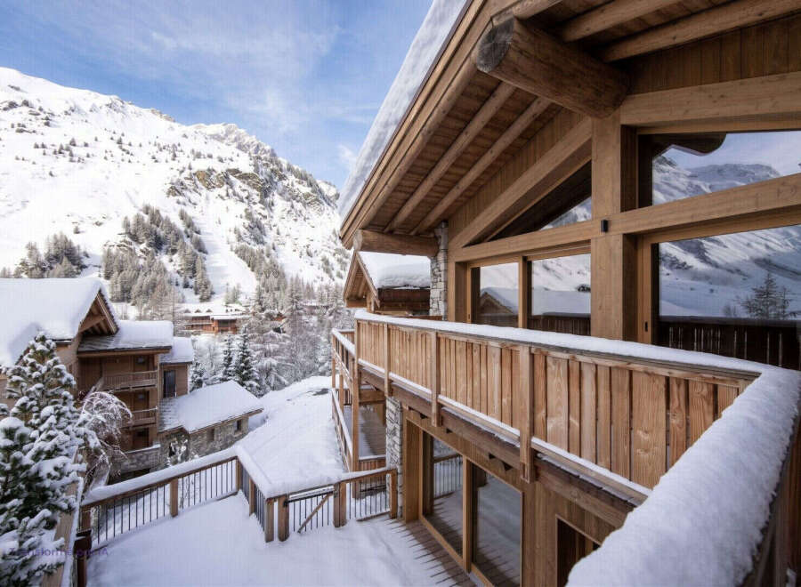 Experience the ultimate alpine retreat in this stunning wooden chalet, nestled amidst snow-covered mountains and evergreen trees.