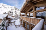 Experience the ultimate alpine retreat in this stunning wooden chalet, nestled amidst snow-covered mountains and evergreen trees.