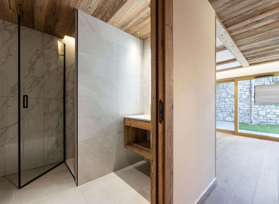Experience modern luxury in this stunning bathroom featuring a spacious marble-tiled shower enclosure with sleek black framing.