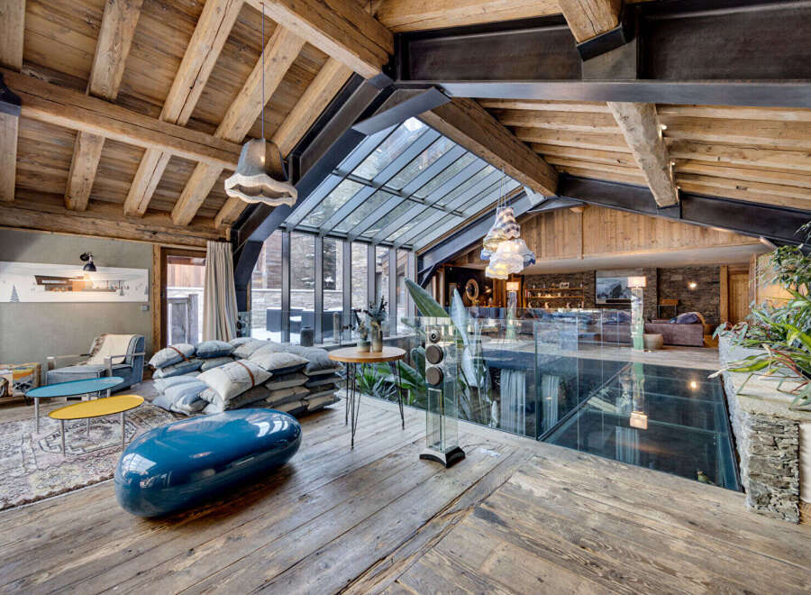 Experience luxury living in this stunning property, featuring a unique glass floor and exposed wooden beams that create a warm and inviting atmosphere.