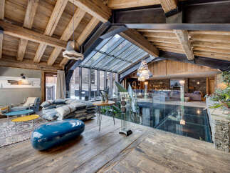 Experience luxury living in this stunning property, featuring a unique glass floor and exposed wooden beams that create a warm and inviting atmosphere.