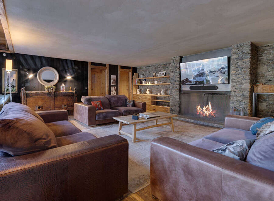 Experience luxury living in this stunning property, featuring a cozy living room with a fireplace and a large TV.