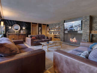 Experience luxury living in this stunning property, featuring a cozy living room with a fireplace and a large TV.