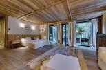 This luxurious bedroom boasts a rustic charm with its wooden ceiling, floors, and headboard.