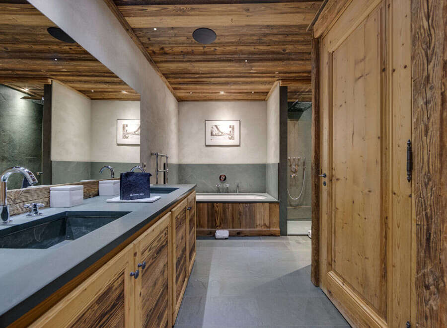 Step into luxury with this stunning bathroom featuring rustic wooden accents and modern amenities.