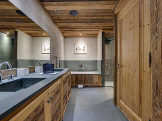 Step into luxury with this stunning bathroom featuring rustic wooden accents and modern amenities.