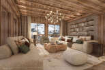 Experience luxury living in this stunning chalet, boasting a cozy living room with a wooden ceiling and large windows offering breathtaking mountain views.