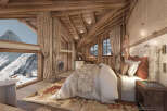 Experience the epitome of luxury in this stunning chalet bedroom, boasting breathtaking mountain views.