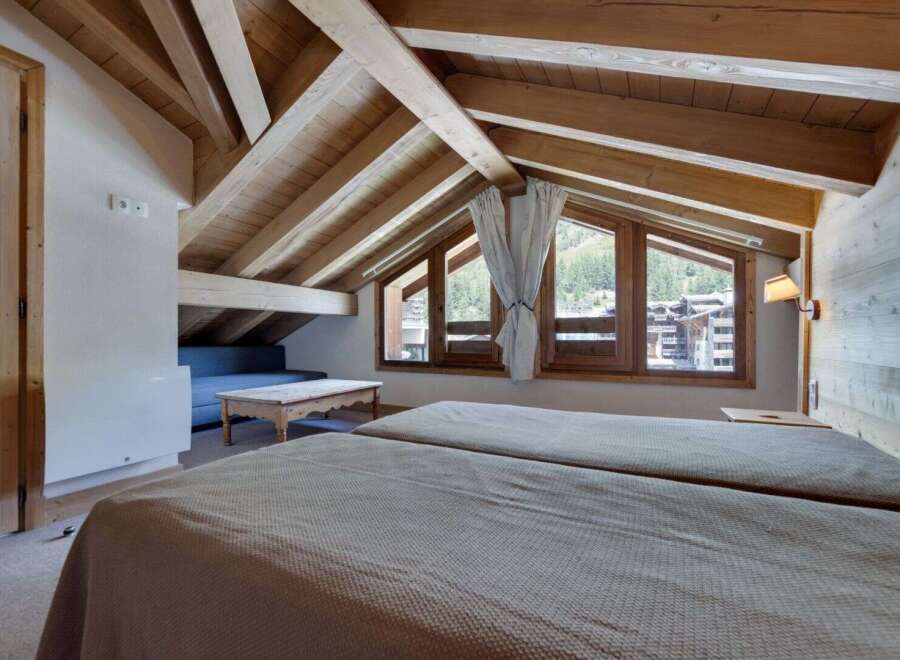 Experience the charm of this cozy bedroom with its rustic wooden beams and inviting ambiance.