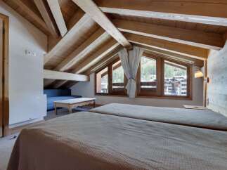 Experience the charm of this cozy bedroom with its rustic wooden beams and inviting ambiance.