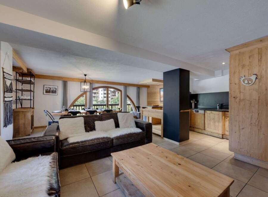 Discover the charm of this stunning property, featuring a spacious living area with a cozy leather sofa and a rustic wooden coffee table.