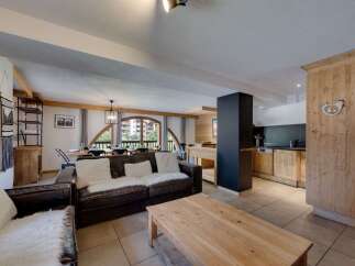 Discover the charm of this stunning property, featuring a spacious living area with a cozy leather sofa and a rustic wooden coffee table.