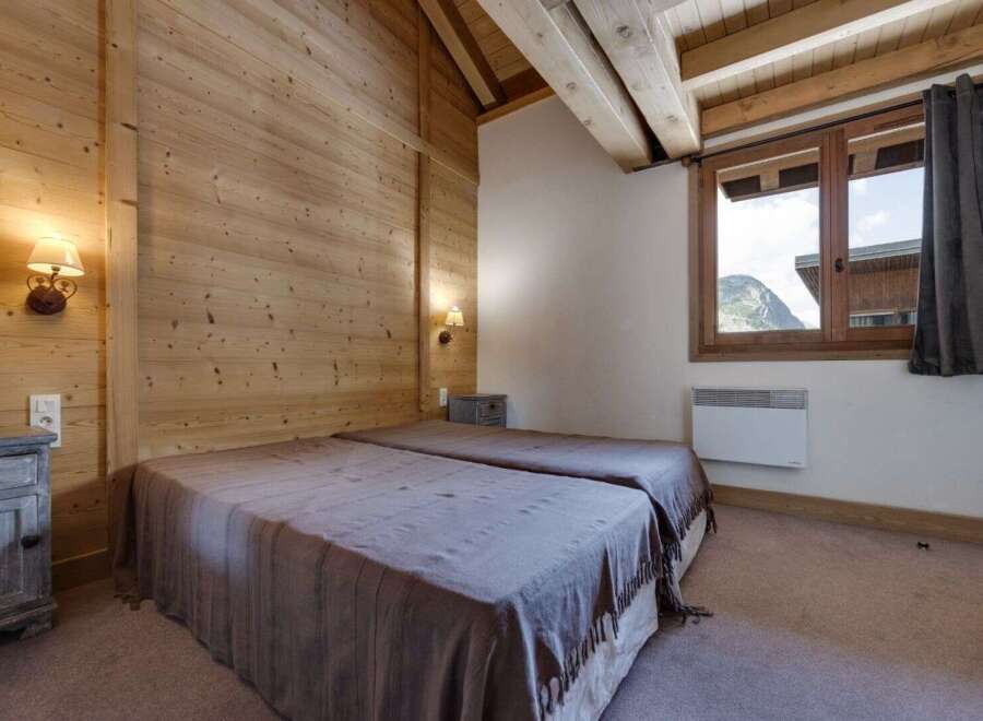 This cozy bedroom features a rustic wooden interior, creating a warm and inviting atmosphere.