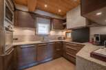 This stunning kitchen boasts a modern design with sleek wooden cabinetry and granite countertops, creating a warm and inviting atmosphere.