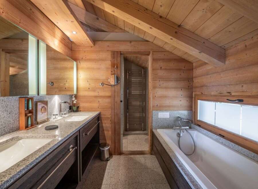 Experience luxury in this stunning bathroom featuring a sleek double vanity with granite countertops and ample storage.