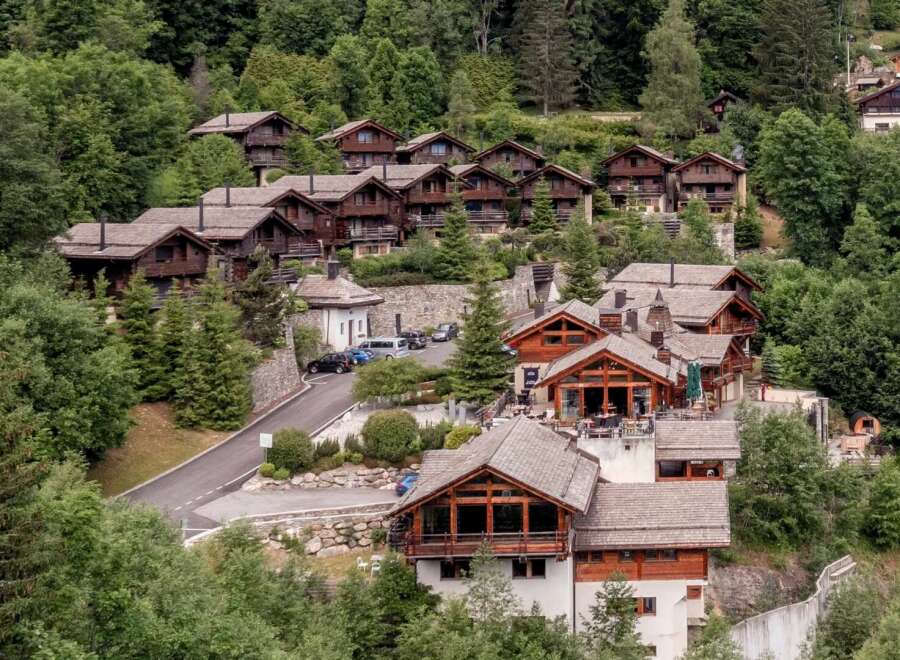 Nestled amidst lush greenery, this stunning property showcases traditional chalet-style architecture.