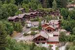 Nestled amidst lush greenery, this stunning property showcases traditional chalet-style architecture.
