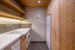This laundry room features a modern design with wooden accents, creating a warm and inviting atmosphere.