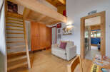 This charming property boasts a unique loft-style design with exposed wooden beams and a cozy living area.