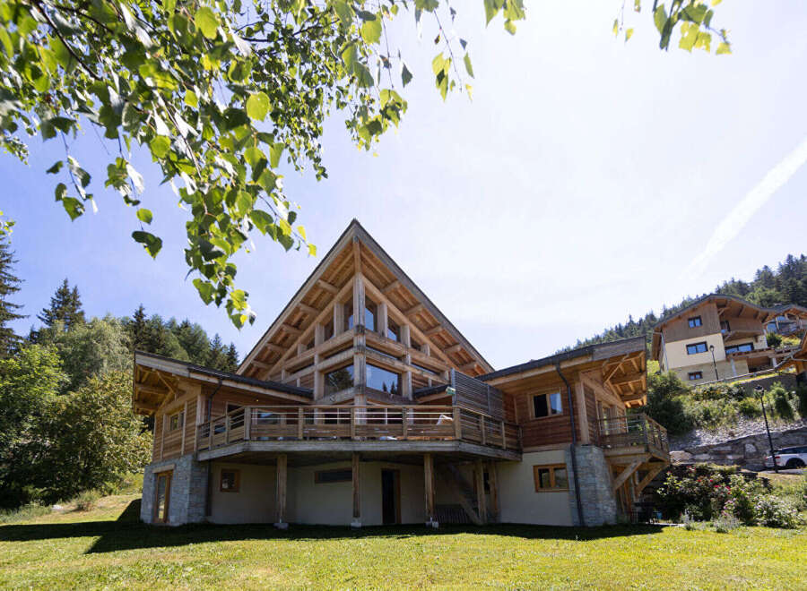 Experience luxury mountain living in this stunning wooden chalet, featuring a striking A-frame design and expansive wrap-around balconies offering breathtaking views.