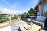 Enjoy breathtaking mountain views from this stunning wooden deck, perfect for al fresco dining or relaxing with a book.