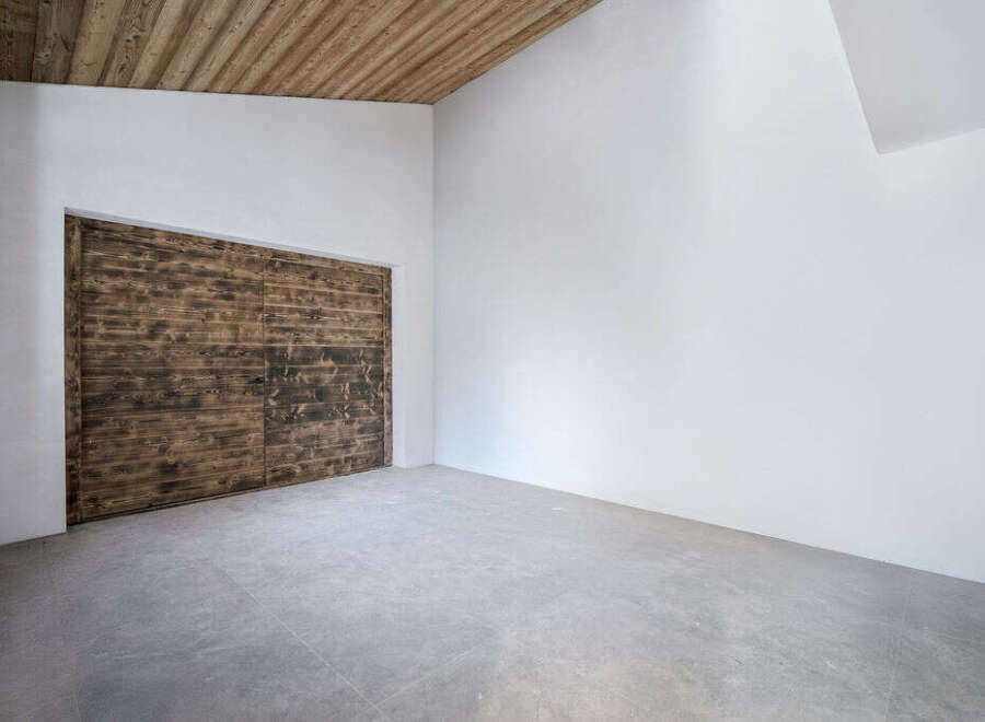 Discover the charm of this unique property featuring a stunning wooden door and a modern, minimalist design.