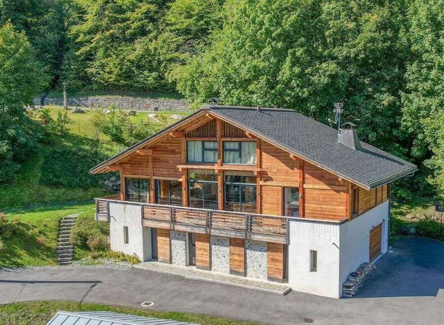 Nestled in a serene, wooded setting, this stunning property boasts a unique architectural design with a blend of wood and stone elements.