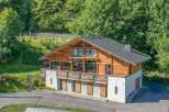 Nestled in a serene, wooded setting, this stunning property boasts a unique architectural design with a blend of wood and stone elements.