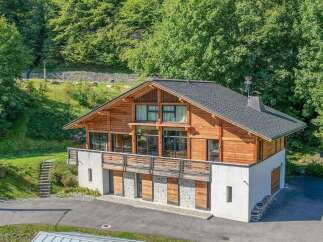 Nestled in a serene, wooded setting, this stunning property boasts a unique architectural design with a blend of wood and stone elements.