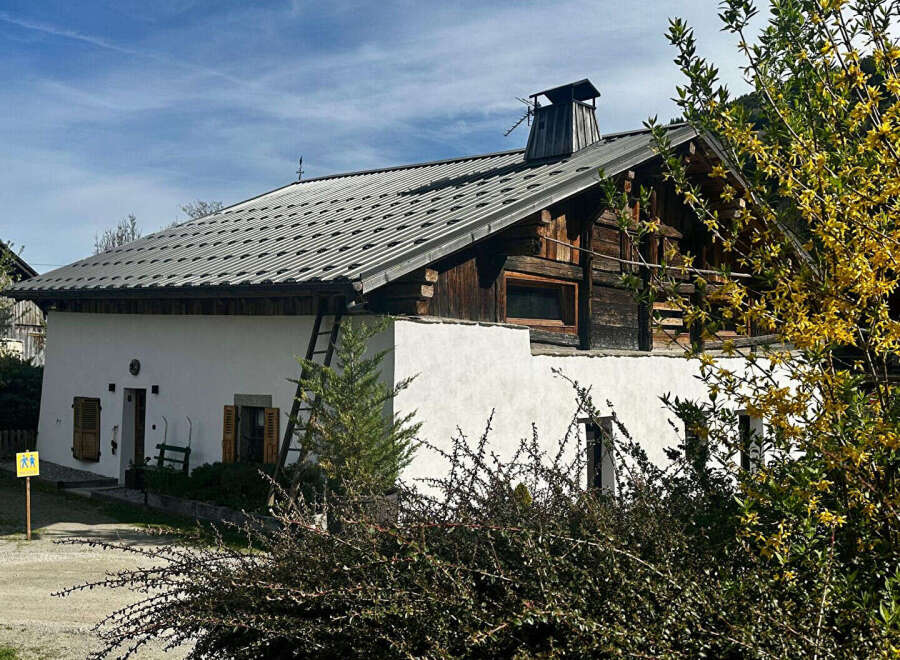 Charming alpine house with a unique blend of traditional wooden architecture and modern white walls.
