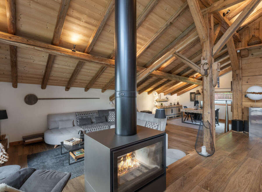 Experience cozy living in this stunning mountain retreat, featuring a modern fireplace as the centerpiece of a spacious, open-plan living area.