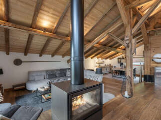 Experience cozy living in this stunning mountain retreat, featuring a modern fireplace as the centerpiece of a spacious, open-plan living area.
