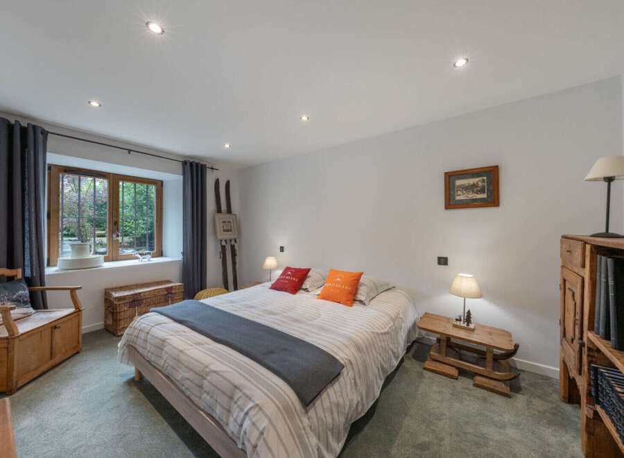 Discover this charming bedroom featuring a comfortable bed adorned with decorative pillows and a cozy throw.