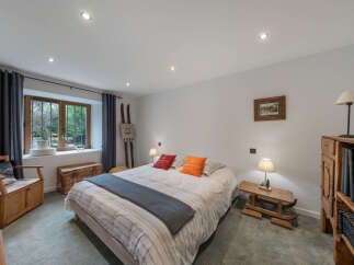Discover this charming bedroom featuring a comfortable bed adorned with decorative pillows and a cozy throw.