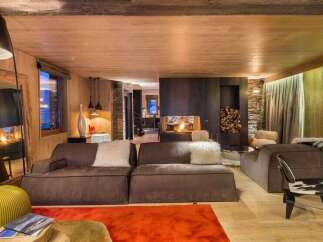 Experience luxury living in this stunning property, featuring a cozy living room with a fireplace and plush seating.