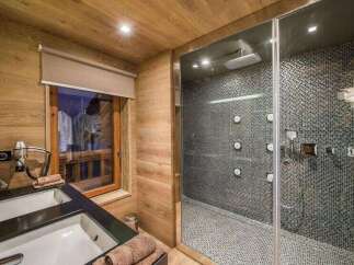 Step into luxury with this stunning bathroom featuring a modern shower and elegant double sinks.