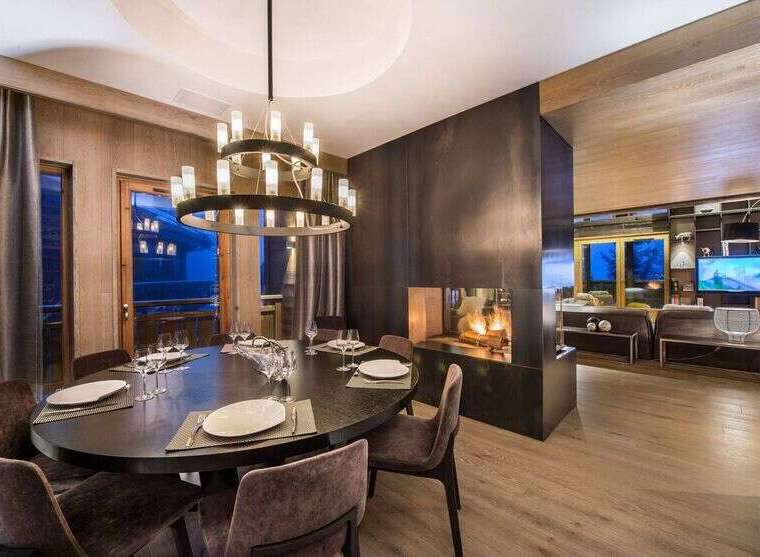 Experience luxury living in this stunning property featuring a modern dining area with a grand chandelier.