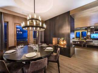 Experience luxury living in this stunning property featuring a modern dining area with a grand chandelier.