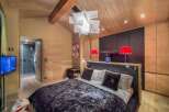 Experience luxury in this stunning bedroom featuring a plush velvet bedspread and a unique geometric chandelier.