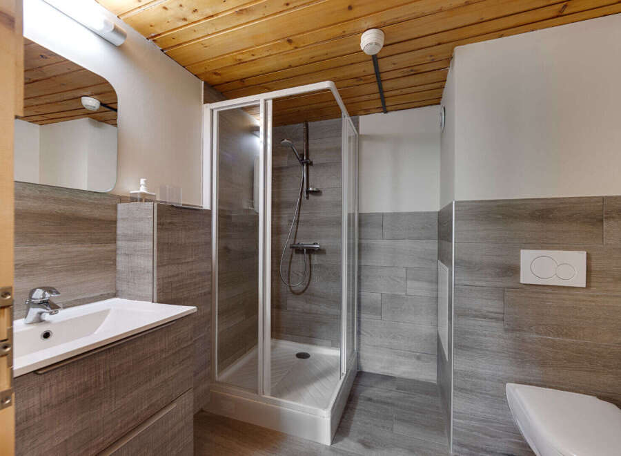 This modern bathroom features a sleek shower, a stylish sink, and a clean toilet.